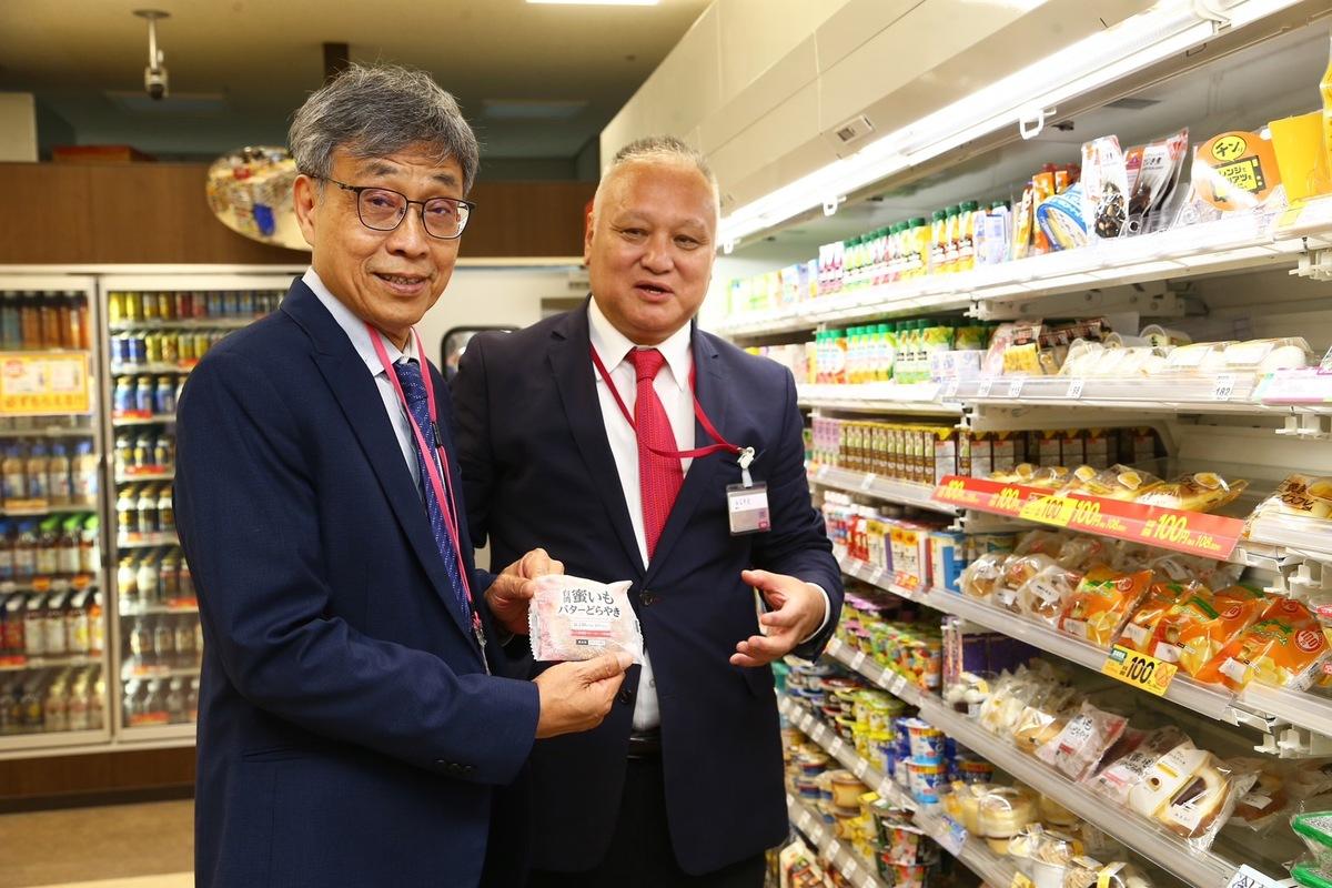 Ministop超商藤本明裕社長(右)向陳駿季部長(左)介紹利用臺灣「台農57號地瓜」製成的門市熱銷商品「地瓜奶油銅鑼燒」 圖：農業部／提供