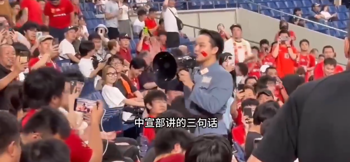 1 名身穿上世紀軍裝的中國男子，在比賽前手持喇叭向中國球迷助威。 圖：翻攝自微博