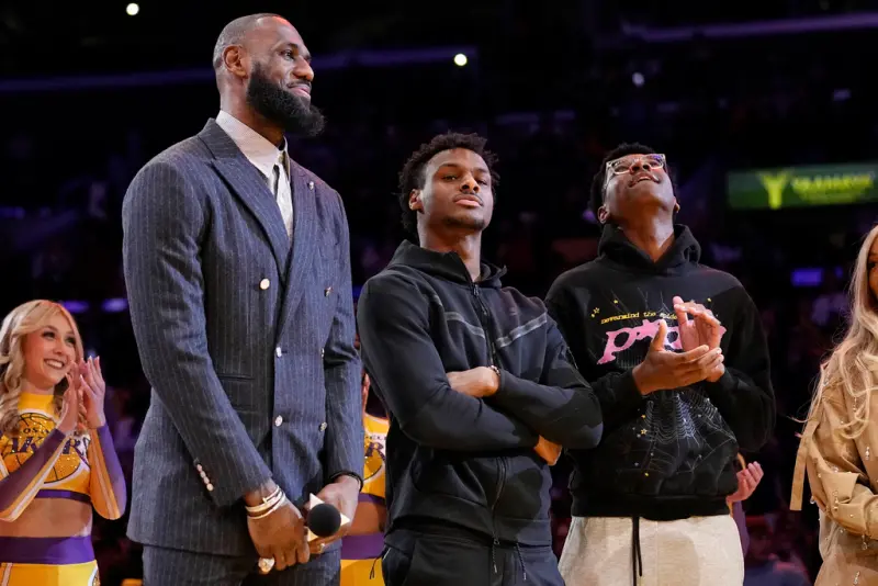 洛杉磯湖人一哥「詹皇」LeBron James(左)，新賽季將與他的大兒子Bronny James(中)攜手替湖人出戰，稍早湖人老闆Jeanie Buss受訪時表示：「我相信他們已做好準備。」 圖：達志影像／美聯社