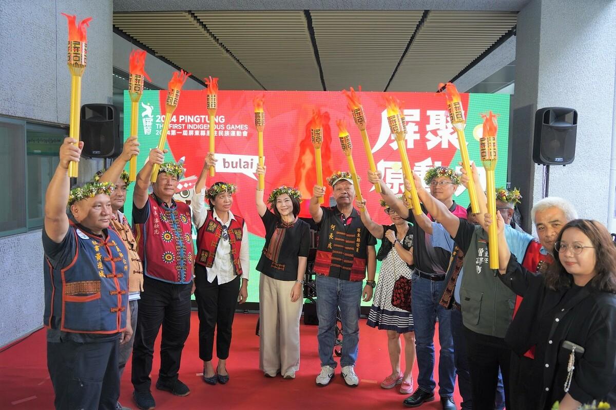 周春米(左五)與各界嘉賓共舉象微性的聖火宣告第一屆屏東縣原住民族運動會正式起跑。 圖：屏東縣政府提供
