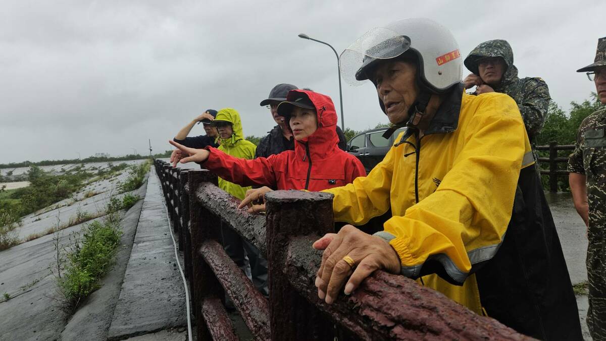 周春米(中)冒雨視察東門溪滯洪池。 圖：屏東縣政府提供