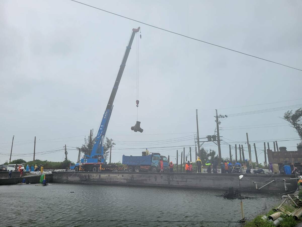 經濟部水利署七河分署調派大型機具，緊急放置消波塊防堵海水持續滲入。 圖：屏東縣政府提供