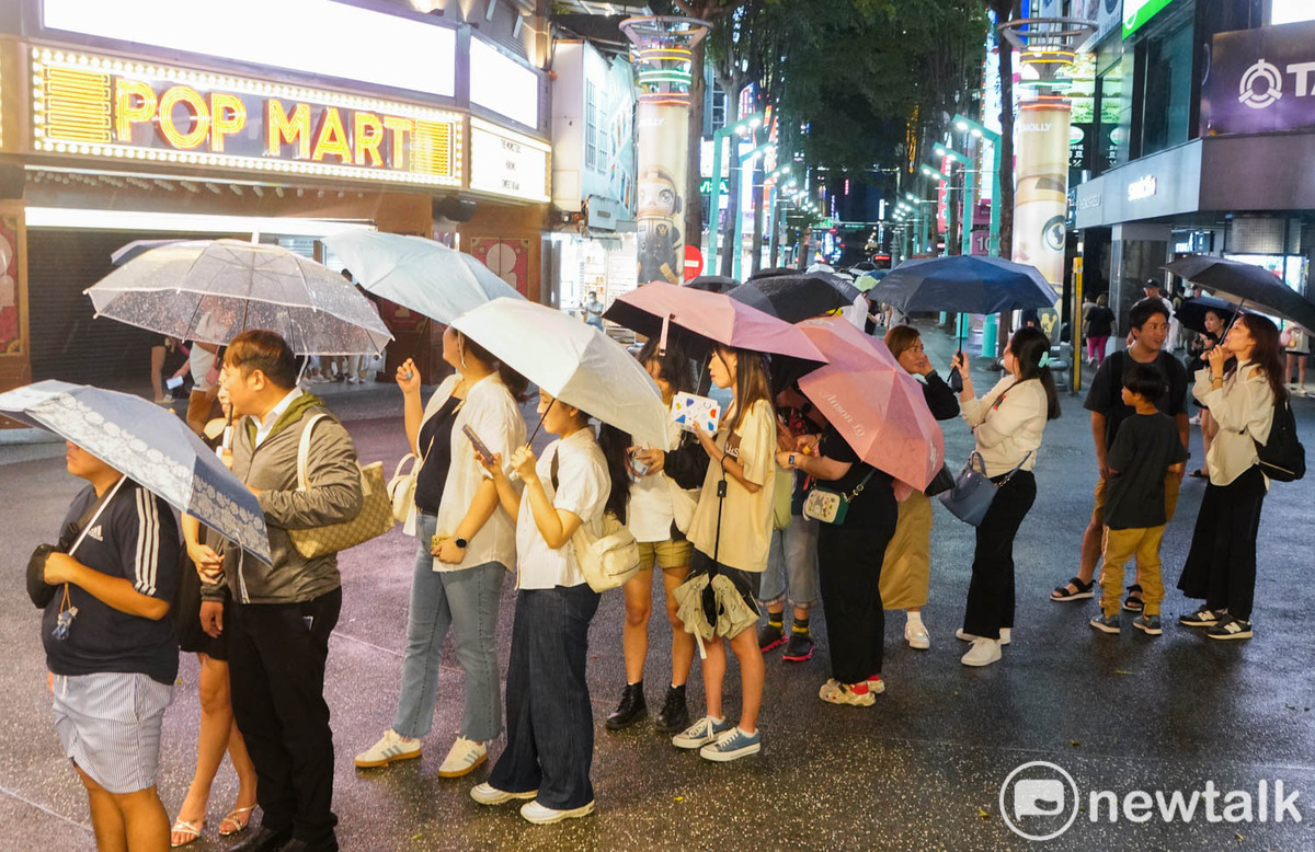 一些民眾和外籍旅客在西門町排隊購買台灣美食。 圖：張良一/攝