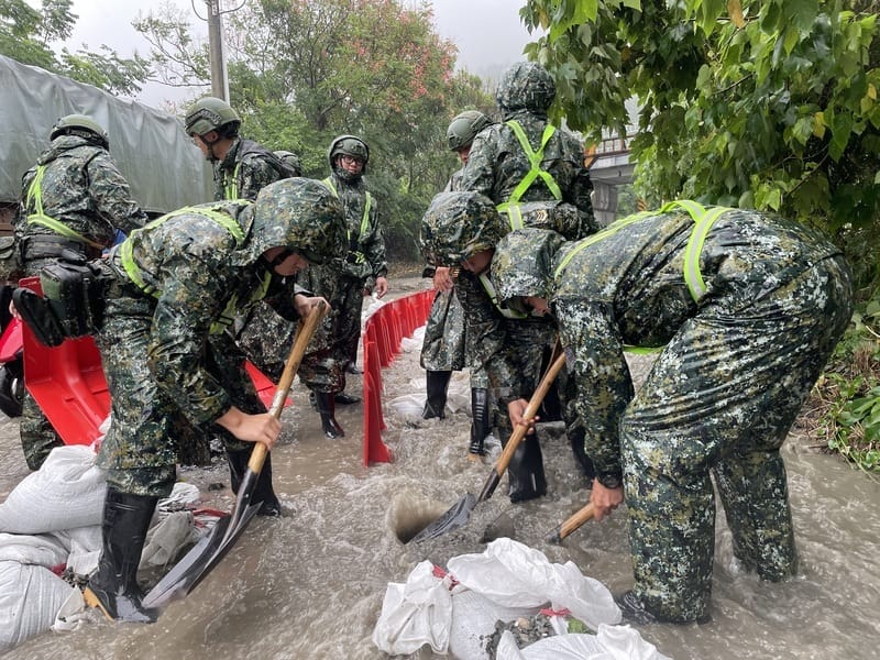 台東縣太麻里鄉沙崙溪溢堤，洪水挾帶土石淹沒前往金針山產業道路和兩旁農田，陸軍第二作戰區3日動員官兵堆沙包、築堤引水導流，防止土石流入村落和街道。 圖：台東指揮部提供