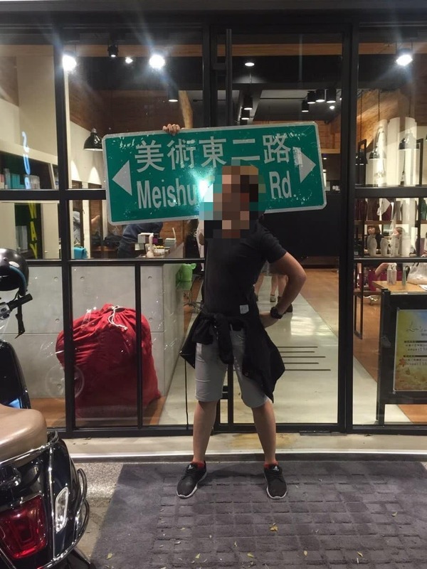 高雄人「全民找路牌」，與掉落的路牌合照，網友直呼「高雄人真的很樂觀」。 圖：取自《高雄點Kaohsiungtien》臉書