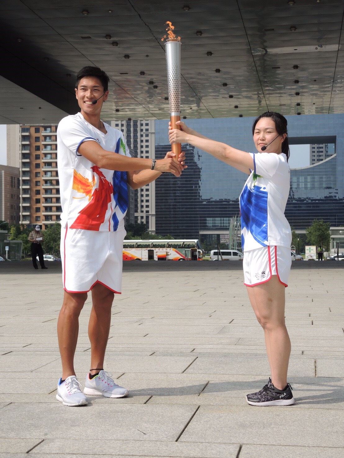 「2017台北世大運」開幕倒數，今(23)日聖火傳遞至台中，現就讀國立台灣體育運動大學研究所的陳傑(左)，是田徑好手。 圖:台中市政府運動局提供