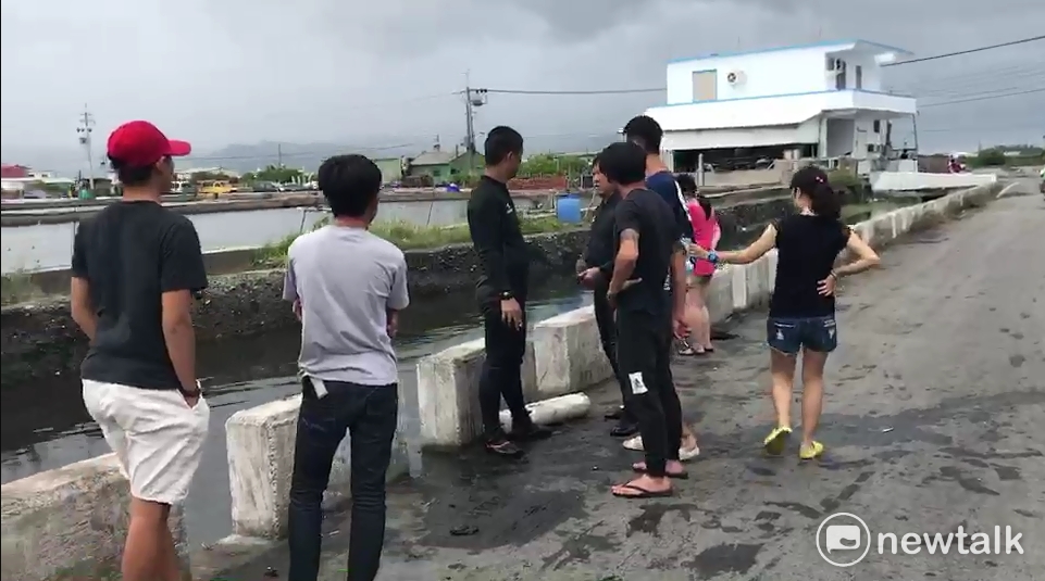 不少民眾圍在大排水溝旁，撈起因暴雨游出養殖魚塘的大魚。 圖：民眾獨家提供