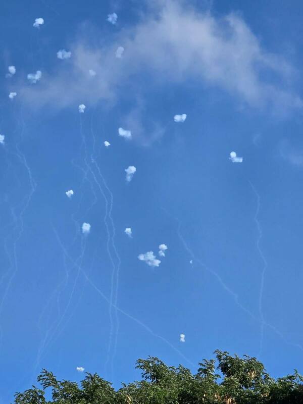 以色列天空散布著真主黨火箭彈飛過後留下的白煙軌跡。 圖：翻攝自 NEXTA X 帳號