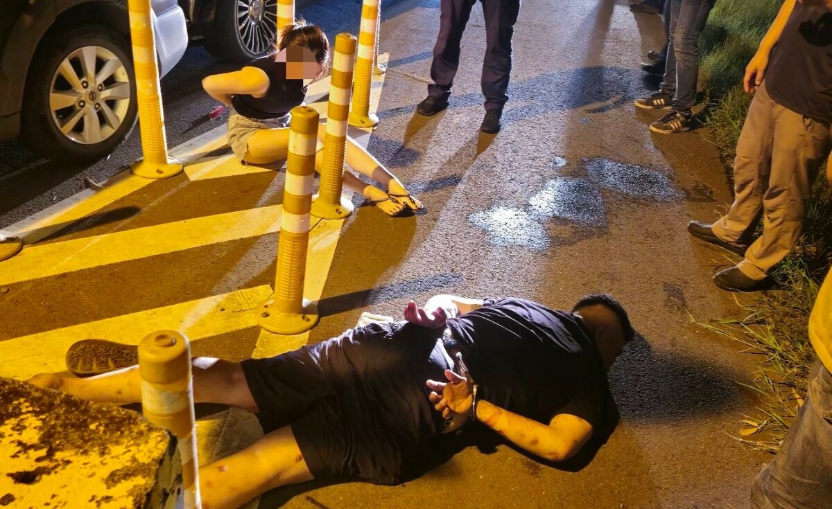 背負四條通的蔡男與王女被制服在地。 圖：高市警三民第一分局提供