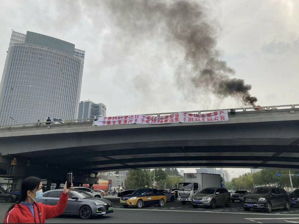 2022 年，中國因 COVID-19 新冠疫情肆虐，各地不時陷入封控狀態，當年 10 月 13 日，男子彭立發在北京四通橋掛出「不要核酸要吃飯，不要封鎖要自由」抗議布條，並因此被警方帶走而失聯至今。 圖：翻攝自 X Bill Birtles