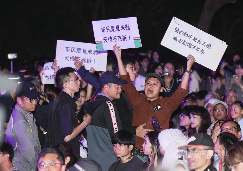 台北市政府日前決議拆除和平新生天橋，有民眾不滿組成團體「守護和平新生天橋」，部分成員2日晚間在白晝之夜活動現場持標語向市長蔣萬安抗議，後續被維安警察帶離現場。 圖:中央社