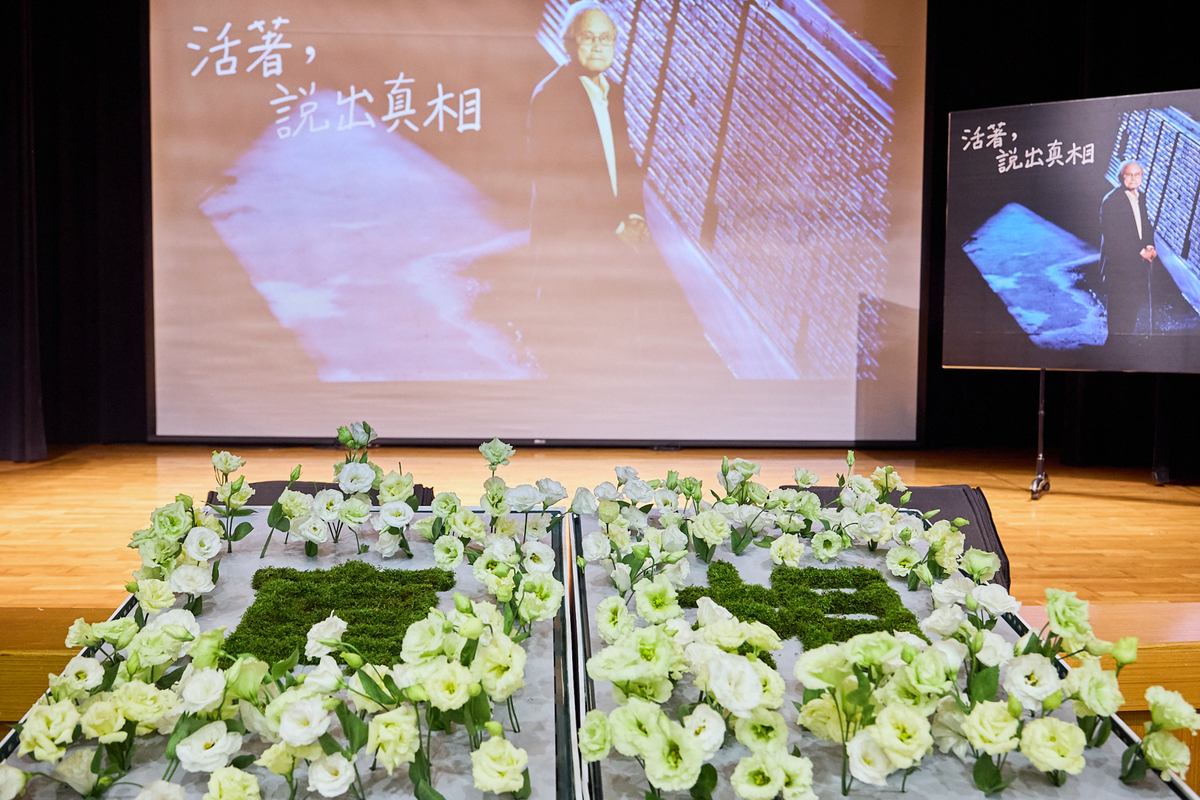 「焠志求真－蔡寬裕先生紀念會」上與會者獻花，將在台前「真相」二字插滿無盡的懷念，以及對蔡寬裕將歷史使命付諸實踐的尊敬。 圖：文化部提供