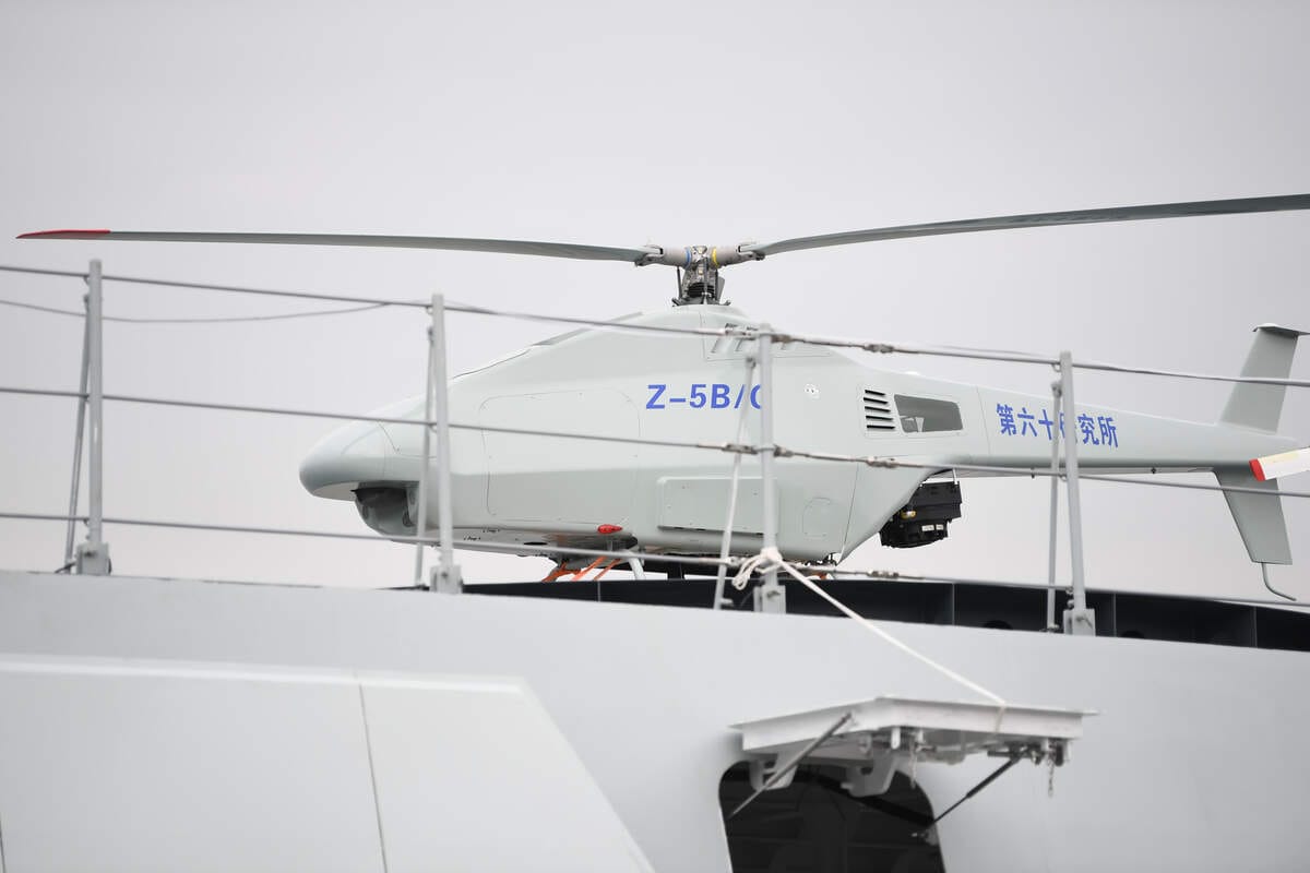 中國第15屆國際航空航天博覽會(珠海航展)中將首次亮相的「虎鯨號」大型無人作戰艇，飛行甲板停放臨時被派遣「充數」的「Z-5B/G」無人偵察機。 圖：翻攝新華社
