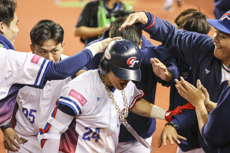 世界12強棒球賽B組預賽正式點燃戰火，13晚間在台北大巨蛋由地主台灣隊與韓國隊交手，台灣隊長陳傑憲（中）2局下接續隊友攻勢敲出2分砲、拉大領先差距，回到休息區後與隊友開心互動慶祝。 圖：中央社
