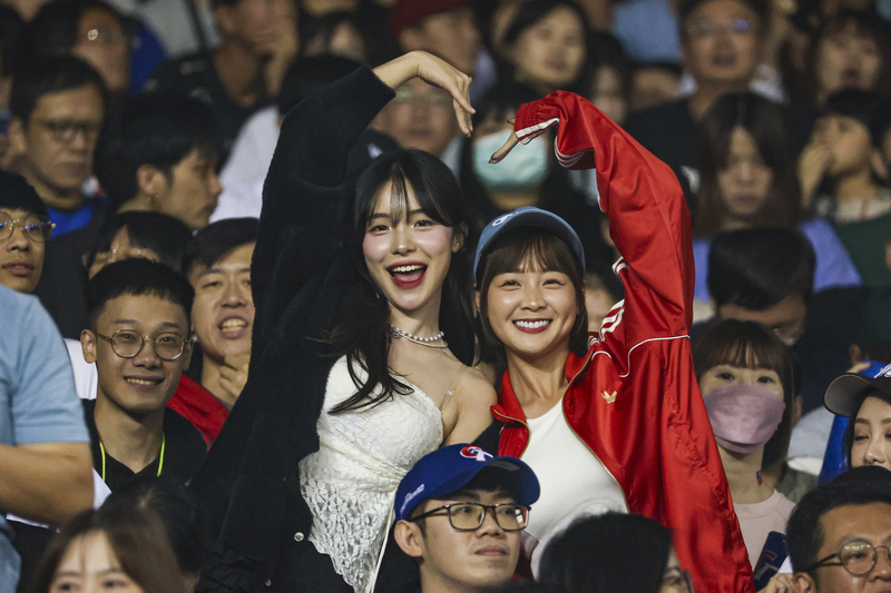 世界12強棒球賽台灣隊B組預賽首戰登場，13日晚間在台北大巨蛋交手韓國隊，中職啦啦隊人氣女孩李多慧（中左）、籃籃（中右）到場觀賽，兩人還在場中合體比出大愛心。 圖：中央社