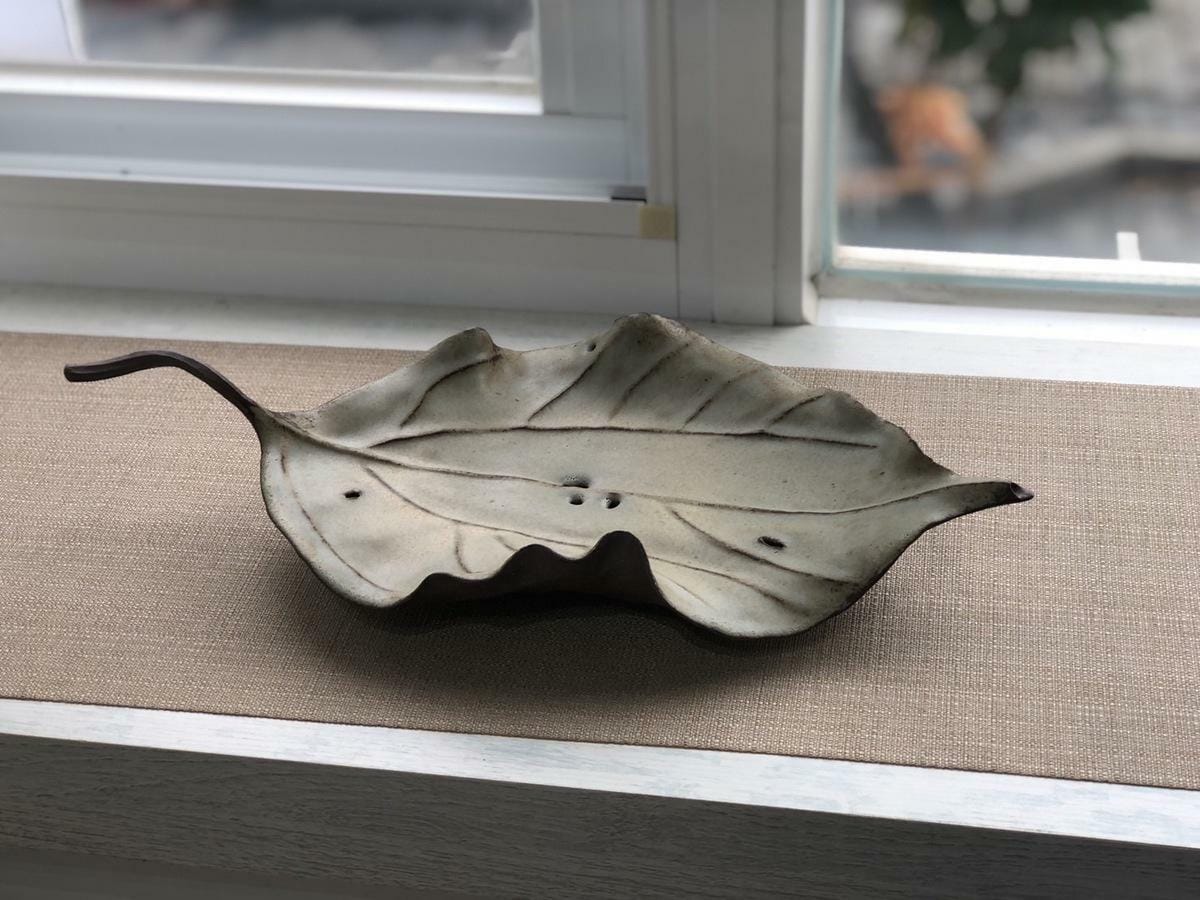 陶藝雕塑作品則以茄苳和樟樹葉為靈感，從具像的壁掛、茶承到抽象的擺件，陳志強希望透過對樹葉形態及釉色的觀察，呈現生命的四時變化和盛衰法則，自然散發生命的通透和心靈沉靜的美感。 圖：黃博郎／攝