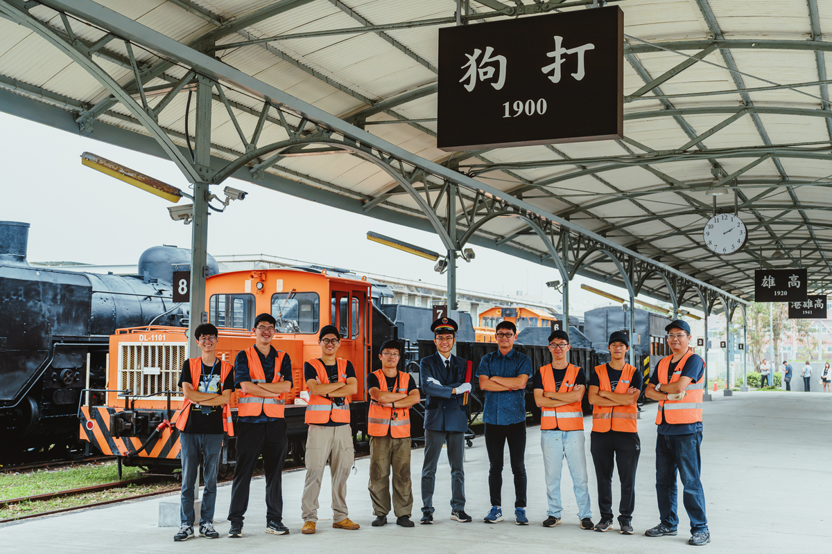 陳其邁(中)與舊打狗驛鐵道工作夥伴於月台「1900打狗」招牌前合影。 圖：高雄市文化局提供