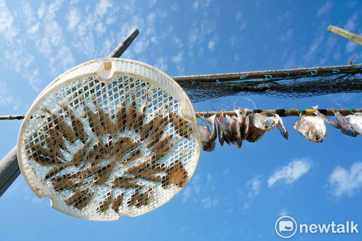 住在東莒的曹祥如將海邊撿來的竹竿、漁網和塑膠籃回收再利用，在院子裡架設曬漁架。 圖：張良一/攝