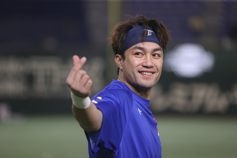 世界12強棒球賽複賽台灣隊22日在東京巨蛋與美國隊交手，台灣隊潘傑楷改守一壘，賽前練習時向現場球迷比出愛心致意。 圖：中央社