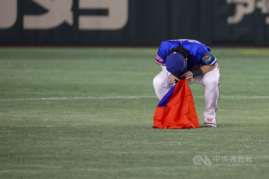 世界12強棒球賽台灣隊24日在東京巨蛋擊敗日本隊成功奪冠，台灣隊長陳傑憲贏得比賽後拿著國旗衝入場中與隊友慶祝勝利，一度情緒激動摀著臉無法起身。 圖:中央社提供