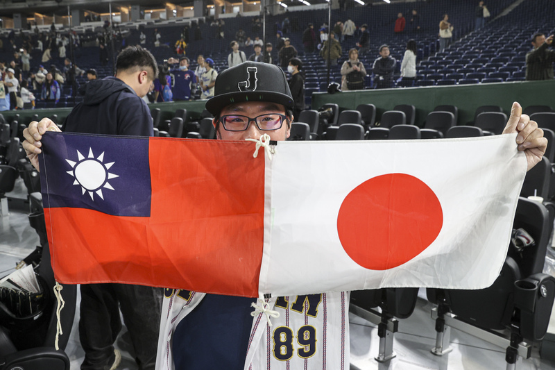 世界12強棒球賽台灣隊24日在東京巨蛋與日本隊交手爭搶冠軍，終場由台灣奪得勝利，場邊有球迷同時舉起台灣與日本國旗象徵台日友好，也為台灣拿勝感到開心。 圖：中央社提供