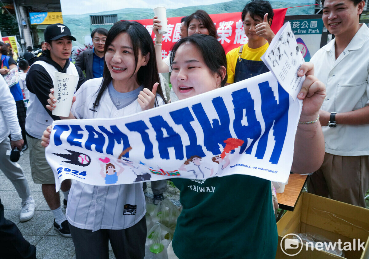 一位女粉絲拿著TEAM TAIWAN 毛巾和吳沛憶合影。 圖：張良一/攝