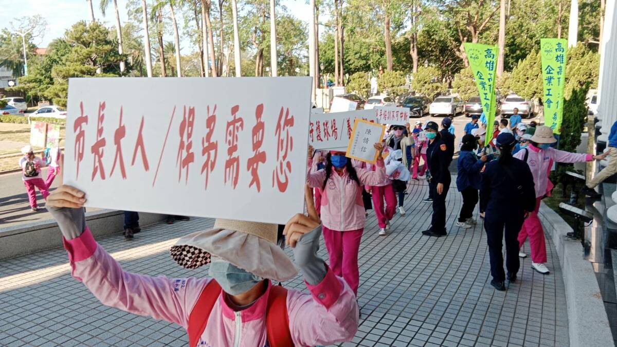 桿娣高舉標語牌進入議會旁聽。 圖：孫家銘攝