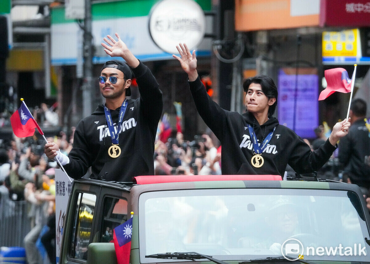 在世界12 強棒球錦標賽奪冠的台灣隊返台後，今天下午以車隊方式參加文化總會舉辦的『棒球英雄 台灣尚勇』遊行，在台日冠軍賽揮出全壘打的陳傑憲和林家正在遊行車隊中，帥氣的向球迷們揮手致意。 圖：張良一/攝