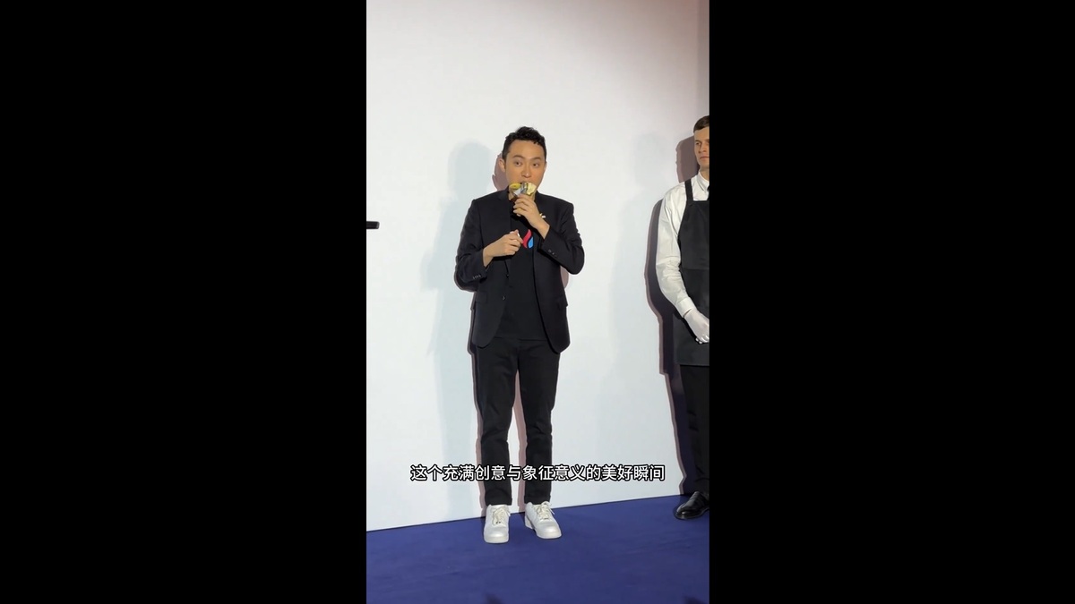 孫宇晨在成功得標「喜劇演員」後，於當地時間 29 日，在香港半島酒店的公開活動中兌現諾言，將香蕉從牆上拿下來吃掉。 圖：擷取自 @sunyuchentron X 分享影片