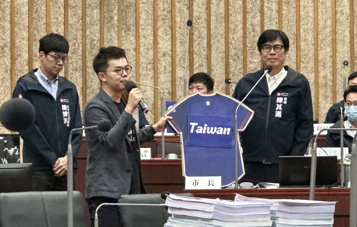 張博洋(左二)質詢時送上球衣，陳其邁(右一)貼上「Taiwan」的牌子。 圖：張博洋服務處提供