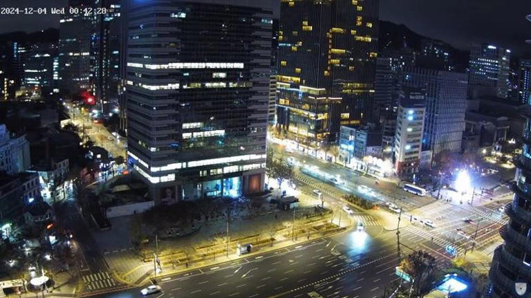 南韓總統尹錫悅3日晚間頒布緊急戒嚴令，但首爾光化門深夜時分仍有不少車輛行駛，甚至偶爾有路人經過。 圖：翻攝自YouTube@GiGAeyes Live TV