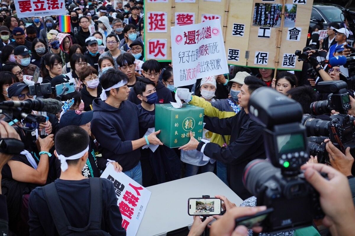 民眾將陳情書投入「功德箱」，要向總統賴清德表達「反霸凌要立法、挺警消要工會、吹哨者要保護」三大訴求。 圖：民眾黨/提供