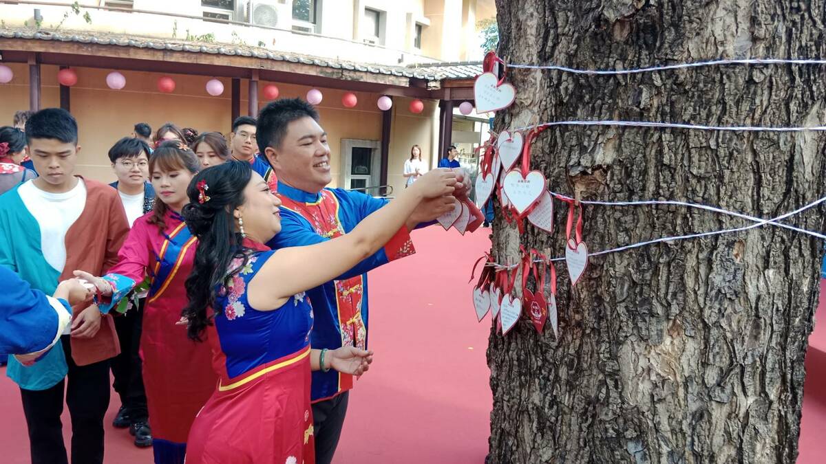 新人將婚禮祝福繫在雨豆樹上。 圖：孫家銘攝