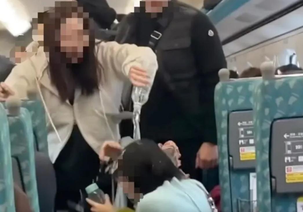 高鐵8日出現搶位事件，一名藍衣女子疑似潑水在男童頭上，男童母憤而回擊，也用礦泉水倒在女子頭上。 圖：翻攝自Threads