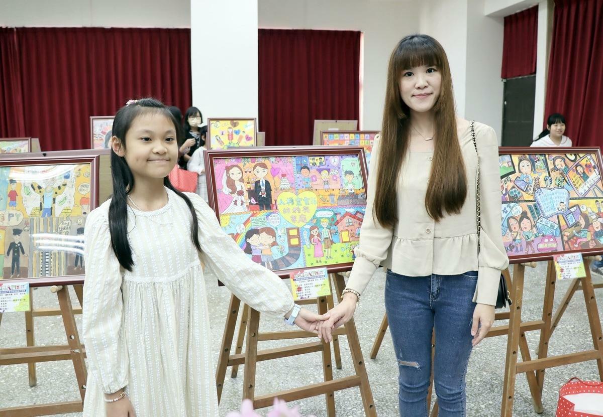 蔡羽晴(左)和媽媽謝緯婷(右)與作品「結婚與家庭」合影。 圖：高雄市教育局提供