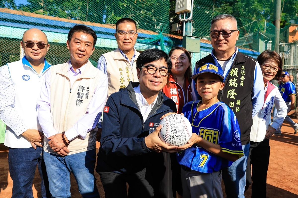 陳其邁(前左)接下復興國小球員的團體簽名球。 圖：高雄市政府提供