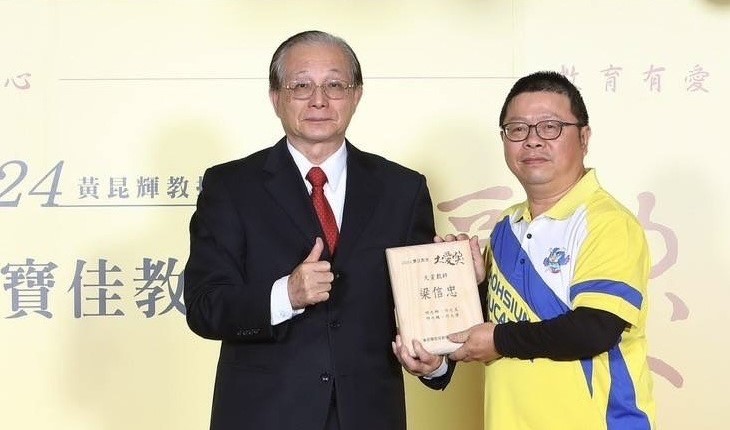 梁信忠(右)自吳清基手中接下「寶佳教育大愛獎」獎牌。 圖：高雄市教育局提供