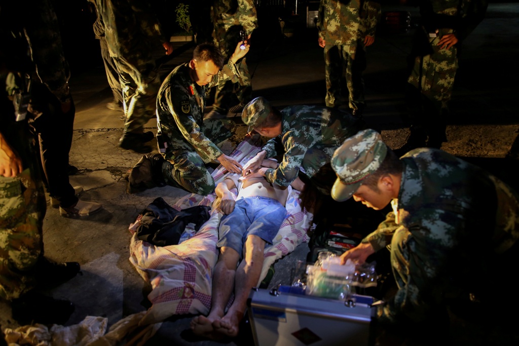 中國四川九寨溝縣等地昨晚發生規模7.0地震。圖為軍方照護倖存者的圖片。 圖：達志影像/路透社