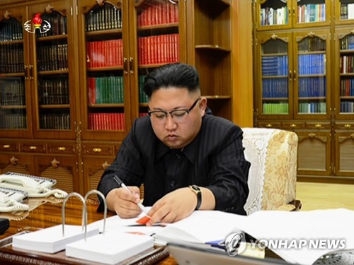 北韓領導人金正恩聽取攻打關島簡報，強調「已進入備戰狀態，隨時突發射擊」。但官媒報導也提到，金正恩會再觀察美國的行動一陣子，暗示他將推遲(hold off)對關島試射導彈計劃。 圖：翻攝自韓聯社網站