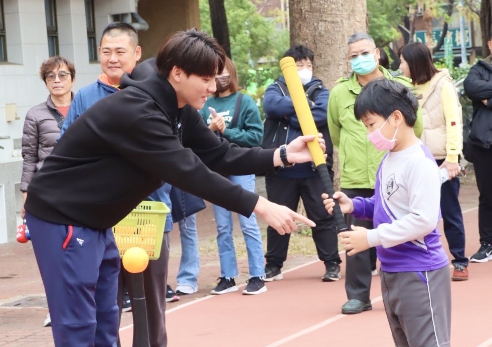 陳晨威(左)指導小學弟打球。 圖：高雄市教育局提供