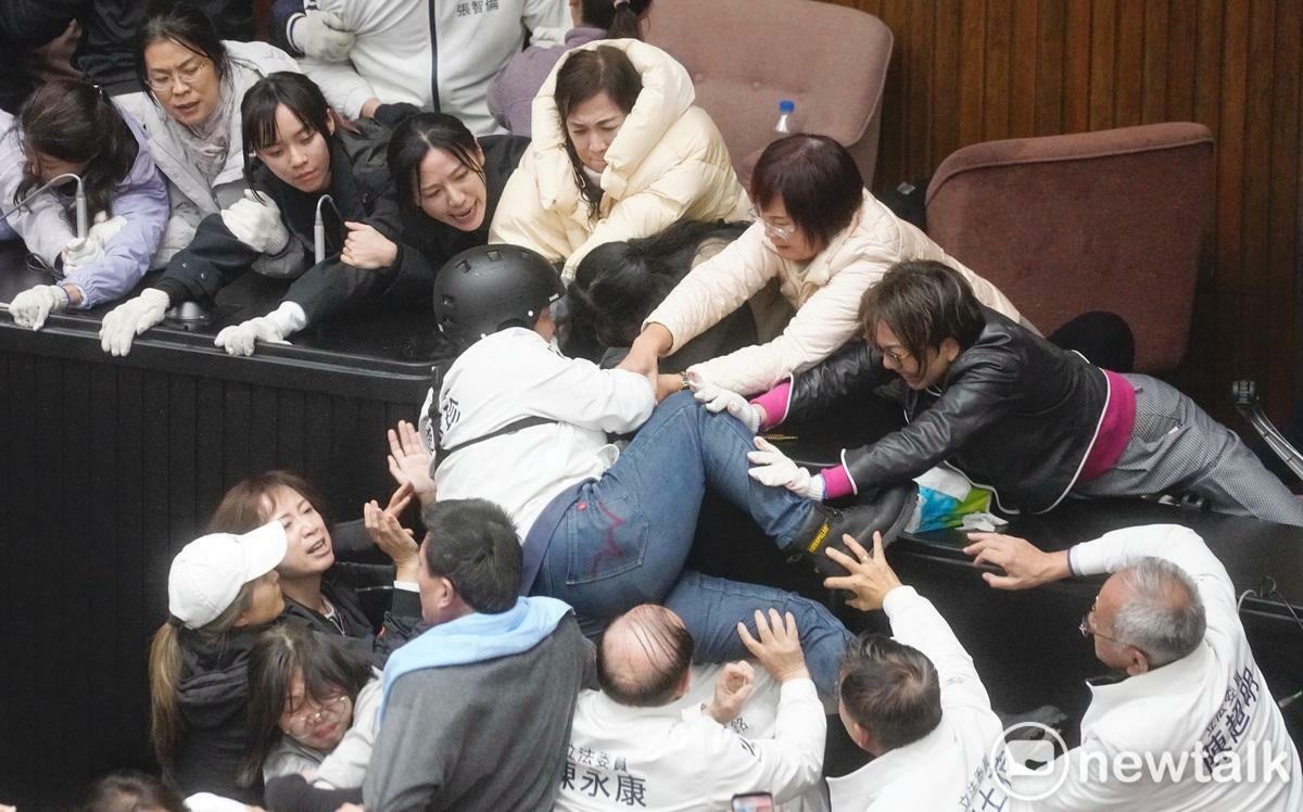 國民黨立委陳玉珍在同黨立委助攻強行登上主席台。 圖：張良一/攝