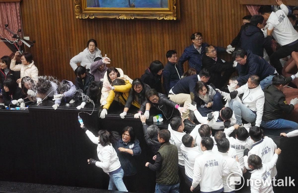 國民黨立委在主席台後方攻出破口後，一一進入議場內，國民黨立委王鴻薇數度水攻主席台上的民進黨立委。 圖：張良一/攝