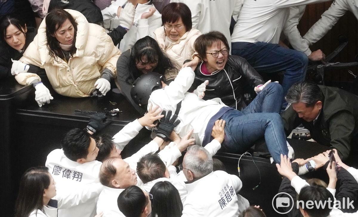 國民黨立委陳玉珍強行爬上主席台，與民進黨立委范雲爆發激烈拉扯。 圖：張良一/攝