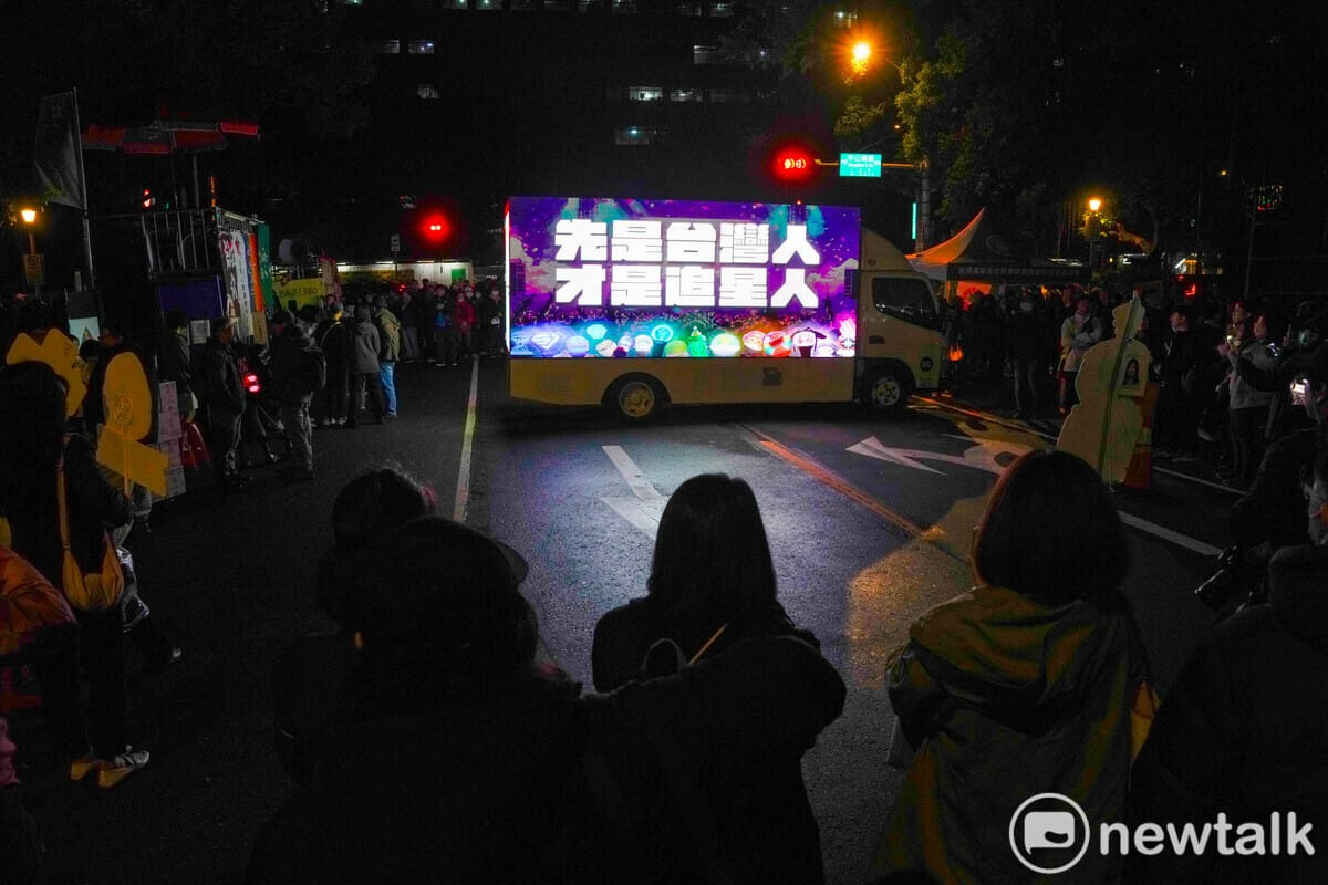 追星人和抗議民眾專注的看著追星民主戰車秀出『先是台灣人 才是追星人』。 圖：張良一/攝