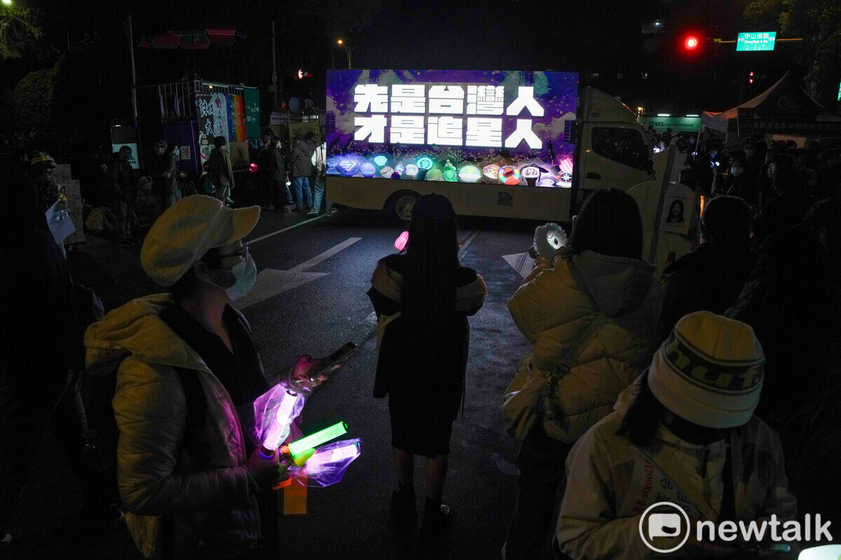追星人和抗議民眾專注的看著追星民主戰車秀出『先是台灣人 才是追星人』。 圖：張良一/攝