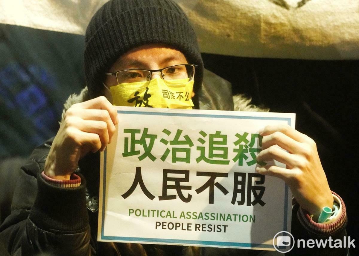 一位民眾黨的支持者在台北地檢署外舉著「政治追殺 人民不服」牌子聲援民眾黨主席柯文哲。 圖：張良一/攝