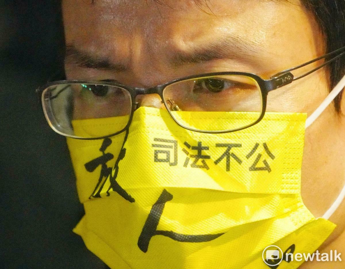 一位民眾黨的支持者在台北地檢署外戴著「放人 司法不公」口罩聲援民眾黨主席柯文哲。 圖：張良一/攝