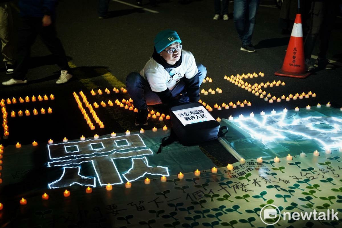 一位民眾黨支持者將放在台北地檢署外，排成Free Kp的蠟燭排好。 圖：張良一/攝