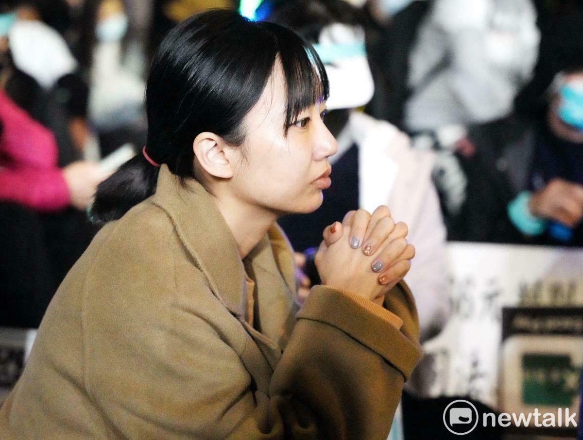 一位民眾黨支持者緊握雙拳在北檢外面守候。 圖：張良一/攝