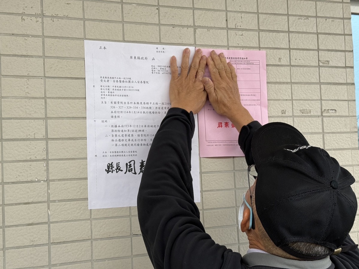 屏縣府派員前往安泰醫院D棟大樓張貼拆除公告。 圖：屏東縣政府提供